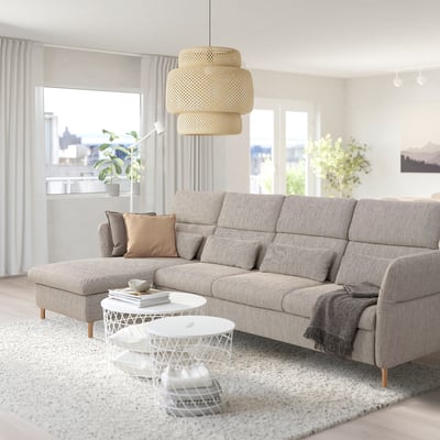 Living room with grey FAMMARP sectional, ottoman, and white coffee table on rug. Natural light and large round light fixture.