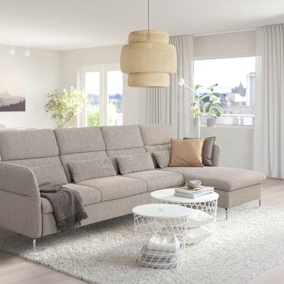 Modern living room with large grey FAMMARP sofa, white rug, stylish pendant lamp, and city view. Sofa has adjustable cushions and high legs.