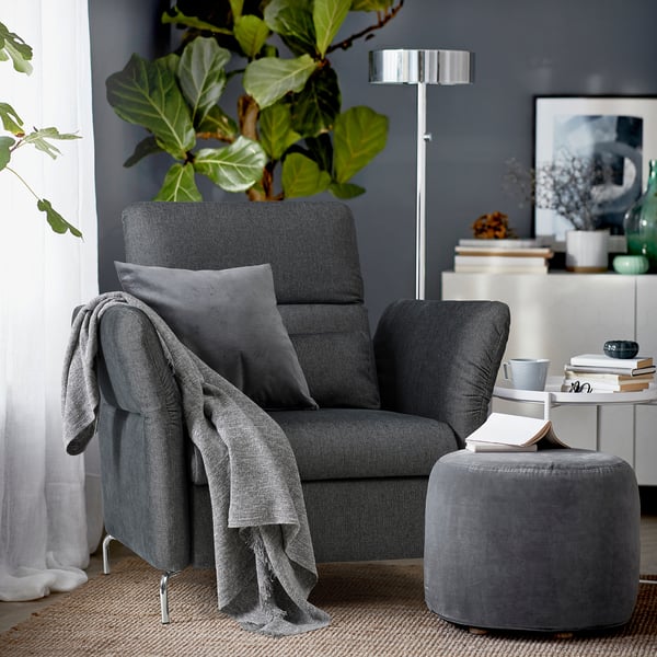 Modern gray FAMMARP recliner with gray throw, pillow & ottoman, cozy & stylish for relaxation.