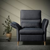 Dark blue FAMMARP armchair with wooden legs, textured fabric, adjustable armrests, set against a plain wall.