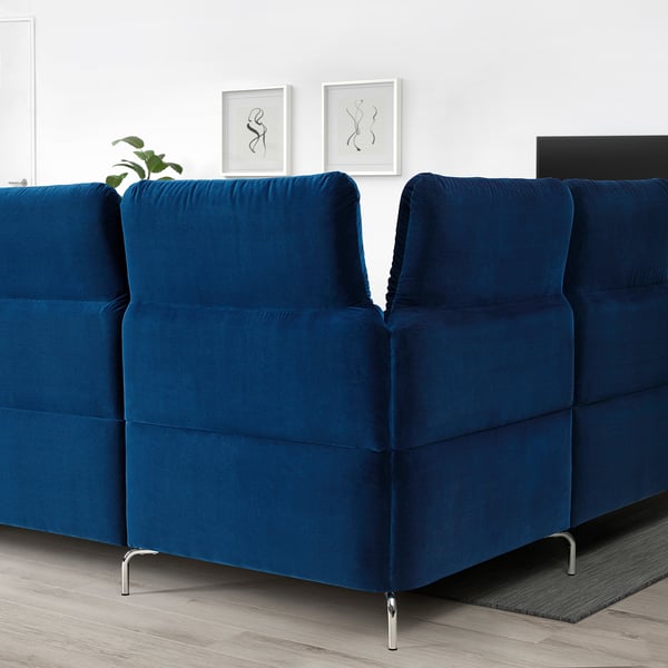 Modern, deep blue FAMMARP sectional sofa with adjustable headrests. Positioned centrally, its larger than surrounding decor.