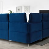 Modern, deep blue FAMMARP sectional sofa with adjustable headrests. Positioned centrally, its larger than surrounding decor.