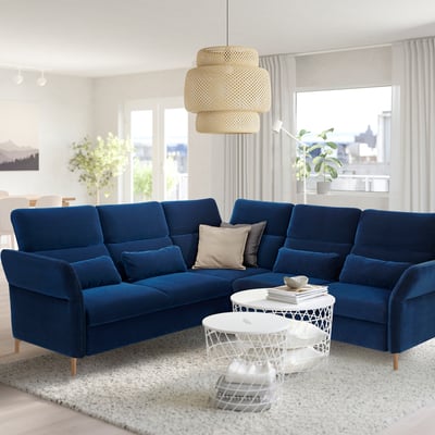 Modern living room with navy blue FAMMARP sectionals, white coffee tables, and a tiered pendant lamp.