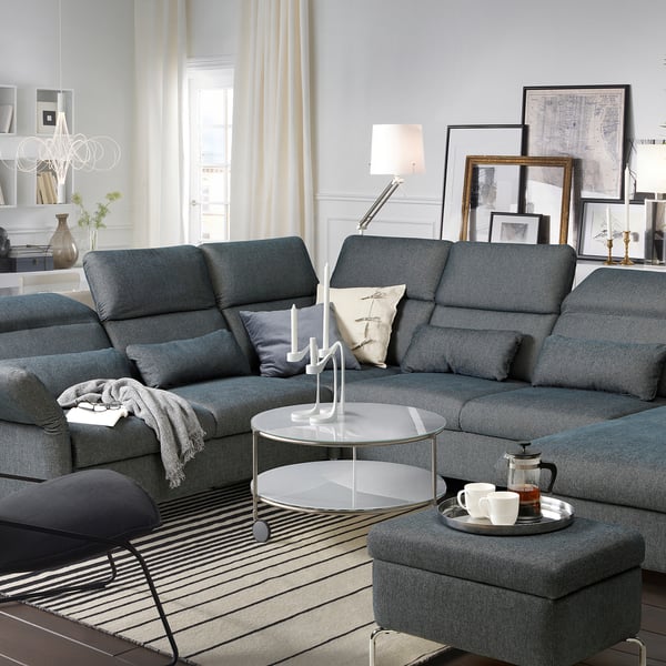Modern living room with dark grey FAMMARP sectional sofa, glass coffee table, and stylish decorations.