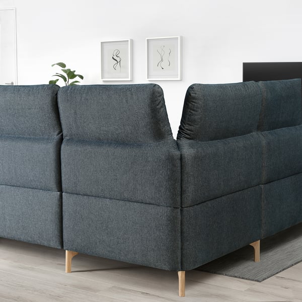 Blue sectional sofa w/adjustable headrests, white wall art, wood floor.