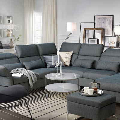 Modern grey FAMMARP sectional sofa with adjustable sections, pillows, coffee table, and rug in a cozy living room setting.