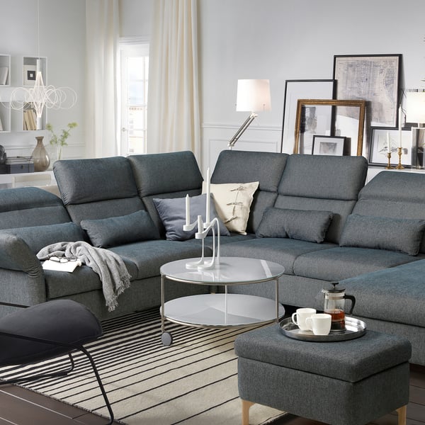 Modern living room with FAMMARP gray sofa, round glass table, and sleek decor.