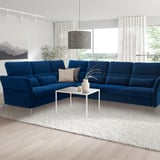Modern blue velvet sectional sofa in spacious living room, luxurious comfort & adjustable support.