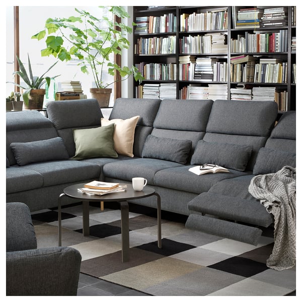 Modern grey sectional sofa with adjustable headrests, cushions, and a coffee table in a cozy living room setting.
