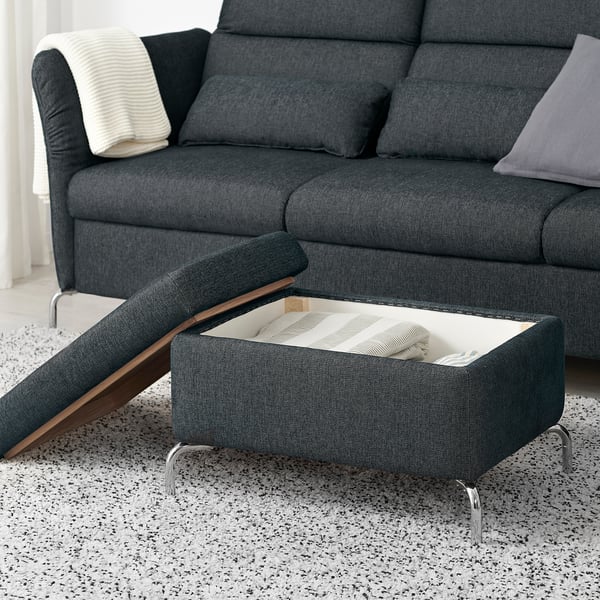 Dark grey sofa with FAMMARP footrest, featuring hidden storage and adjustable seats. Footrest shows striped blanket inside open compartment.