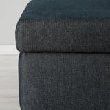 Close-up of dark cushioned ottoman, showcasing sturdy, high-quality fabric and plush comfort.