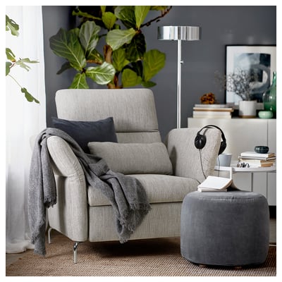 Cozy grey recliner chair with headphones, throw, and side table.