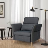 Modern grey FAMMARP recliner beside a tall black lamp. Soft, adjustable, fits cozily next to side table.