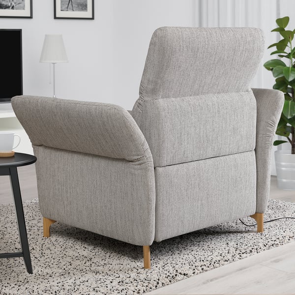 Modern recliner chair FAMMARP in gray fabric, high back & armrests, sits near plant & side table.