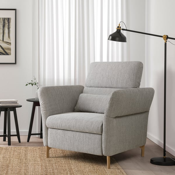 Minimalist living room with gray recliner, black lamp, side table, and art.