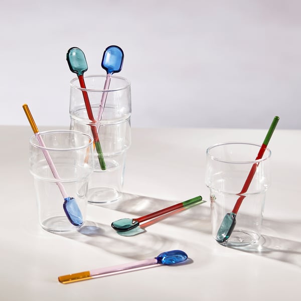 Colored glass spoons in clear glasses, showcasing heat resistance and easy grip.