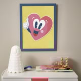 Colorful framed heart lamp on wall.
