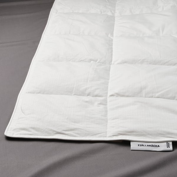 White duvet on bed with fjällräcka label, showing light, soft texture.