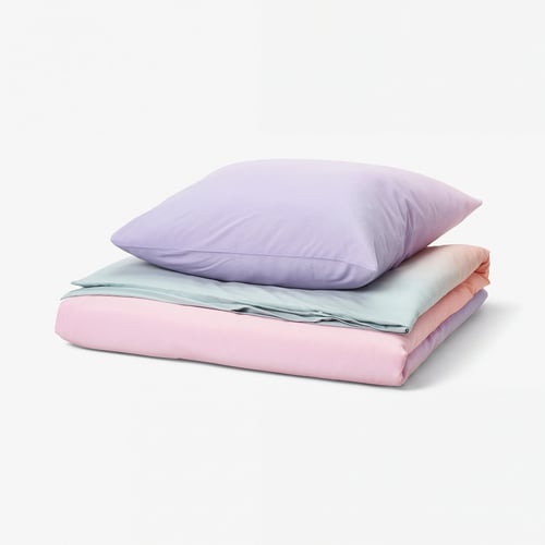 A folded FLÄDERBUSKE bedding set in purple, pink, and light blue. The material appears soft and colourful with a gradient design.