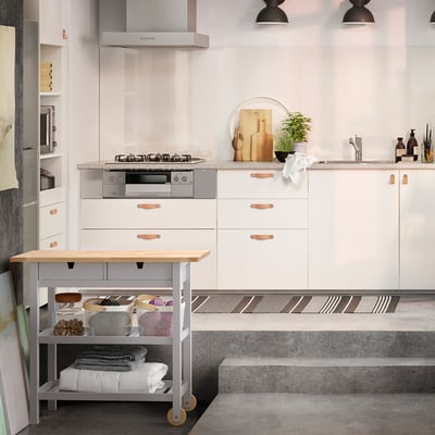 Modern kitchen with FÖRHÖJA trolley, wooden surfaces, and ample storage.