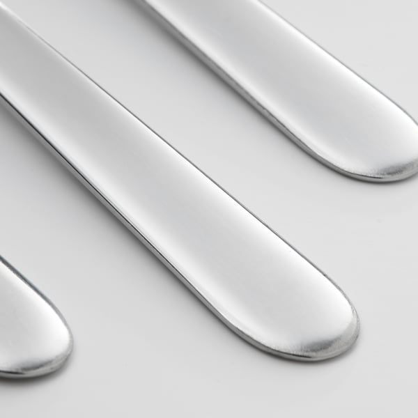 Polished, stainless steel spoons arranged neatly.