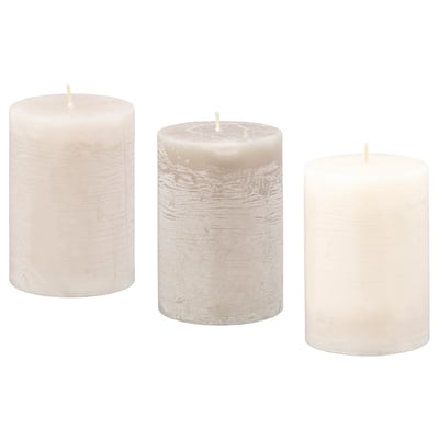 Three unscented cylindrical candles of different shades of white, made from paraffin and vegetable wax, aligned side by side.