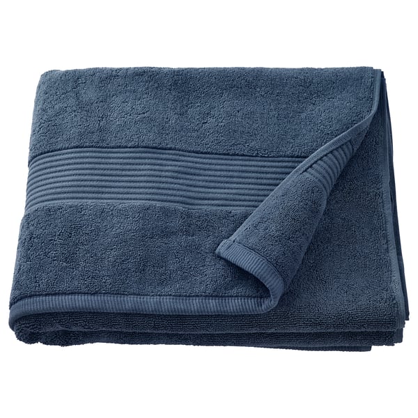 A folded FREDRIKSJÖN towel in dark blue, made of thick, soft cotton with a woven border detail.