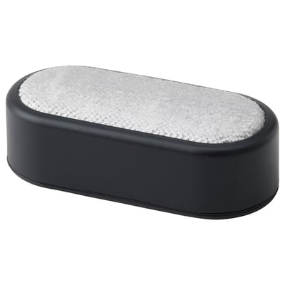 A black oval-shaped lint brush with a white fuzzy surface, designed to remove lint and hair from clothes.