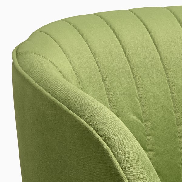 Close-up of stylish, green barrel chair, showcasing tufted back and smooth upholstery.