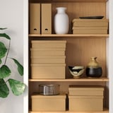 Wooden shelves storing cardboard boxes and decorative items, including vases and bowls.