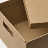 Closed brown cardboard box with cut-out handle, shown from an angled view.