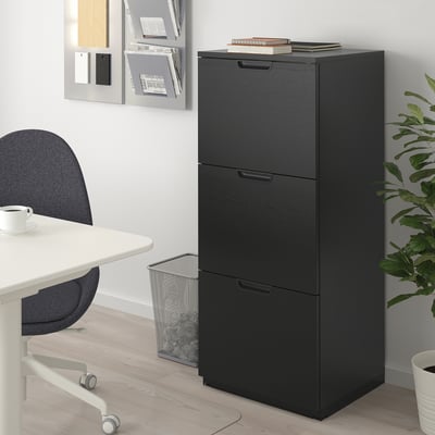 Black filing cabinet with 3 drawers & lock in office, taller than chair.