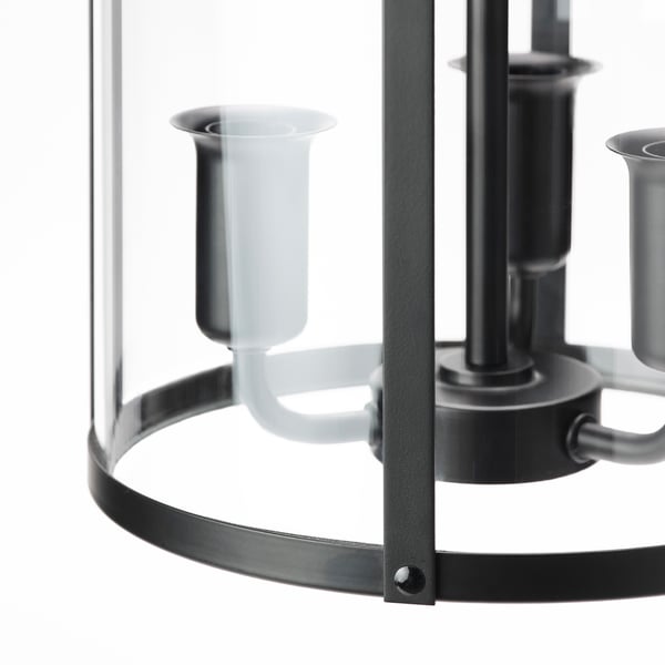 Modern chandelier with clear glass and black metal frame, featuring three frosted glass candle holders.