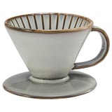 A white ceramic coffee dripper, part of the GLADELIG series. It a handle and is designed to brew coffee.