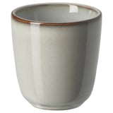 Glazed ceramic mug, sand color, round shape with rustic edges, part of the GLADELIG series.