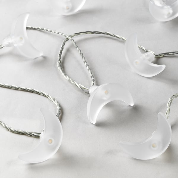 Image a string of led lights shaped like crescent moons, neatly arranged on a white surface, highlighting their sleek and modern design.