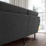 Dark grey 4-seat sofa, modern, comfortable, high on metal legs, fits spacious rooms.