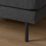 Dark gray fabric sofa with cylindrical metal leg on wooden floor.