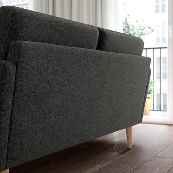 Modern grey GRILLSTORP sofa by window with wooden legs and cushions.