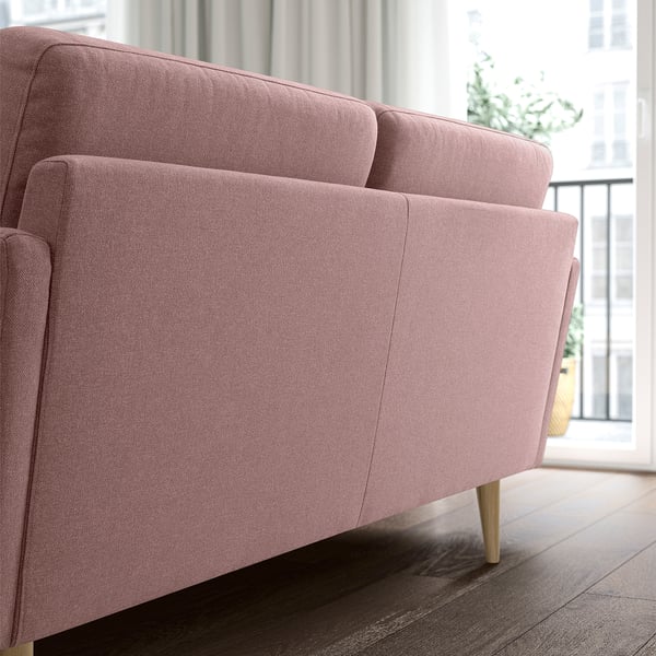 Modern pink fabric sofa, clean lines, sturdy wooden legs, smaller size.