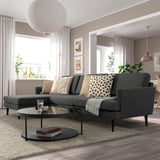 Modern living room with GRILLSTORP sectional sofa, throw pillows, glass coffee table, paper lantern light, plants, and large windows.