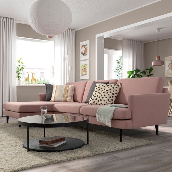 Pink sectional sofa with colorful pillows and glass coffee table in modern living room