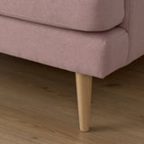 Close-up of modern sofa leg, smooth wooden finish. Soft, light purple upholstery, cozy design.