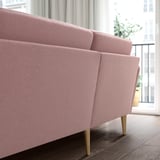 A pink GRILLSTORP 4-seat sofa with wooden legs. Its large and has a clean, inviting design, perfect for a cozy living space.
