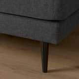 Close-up of dark fabric sofa leg on wooden floor. Sofa appears soft, sturdy, and stylish.