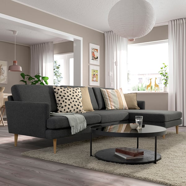 Gray GRILLSTORP sofa, plush cushions, black coffee table, pendant light, large window.