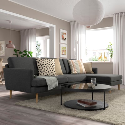 Gray GRILLSTORP sofa, plush cushions, black coffee table, pendant light, large window.