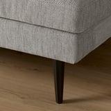 Modern sofa with sleek wooden legs, upholstered in textured fabric, showcasing quality design and comfort.