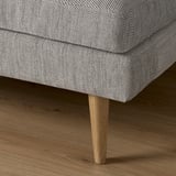 Sofa with patterned fabric and wooden legs. Upholstered cushions for comfort.