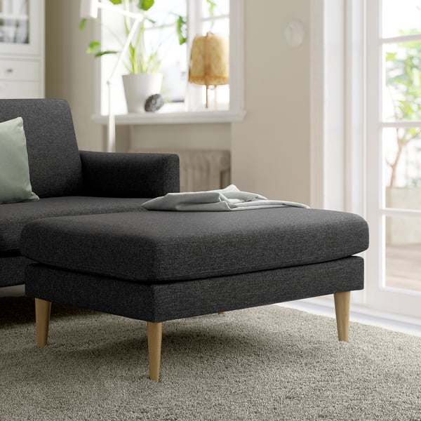 Dark grey GRILLSTORP sofa with ottoman, light-filled living room.